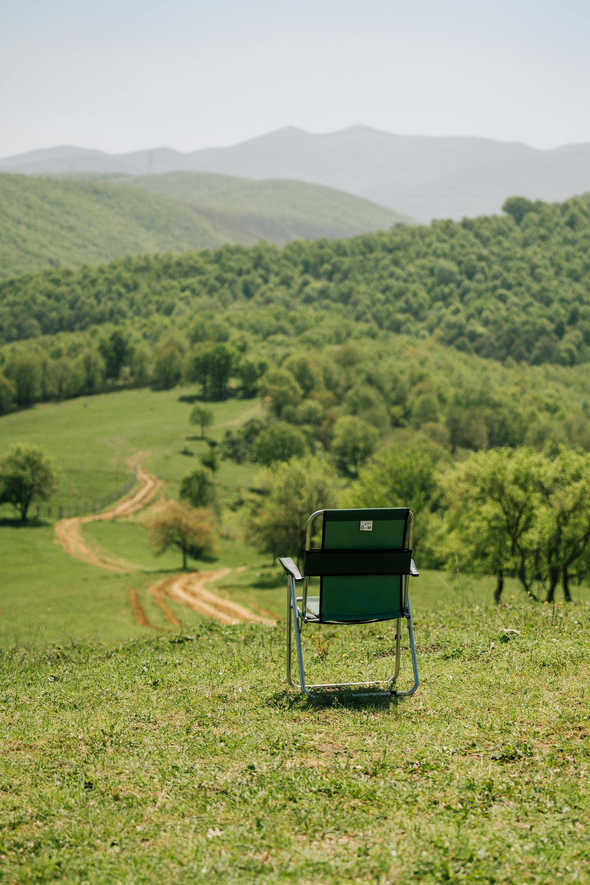Single folding camping chair set up outdoors in an open field
