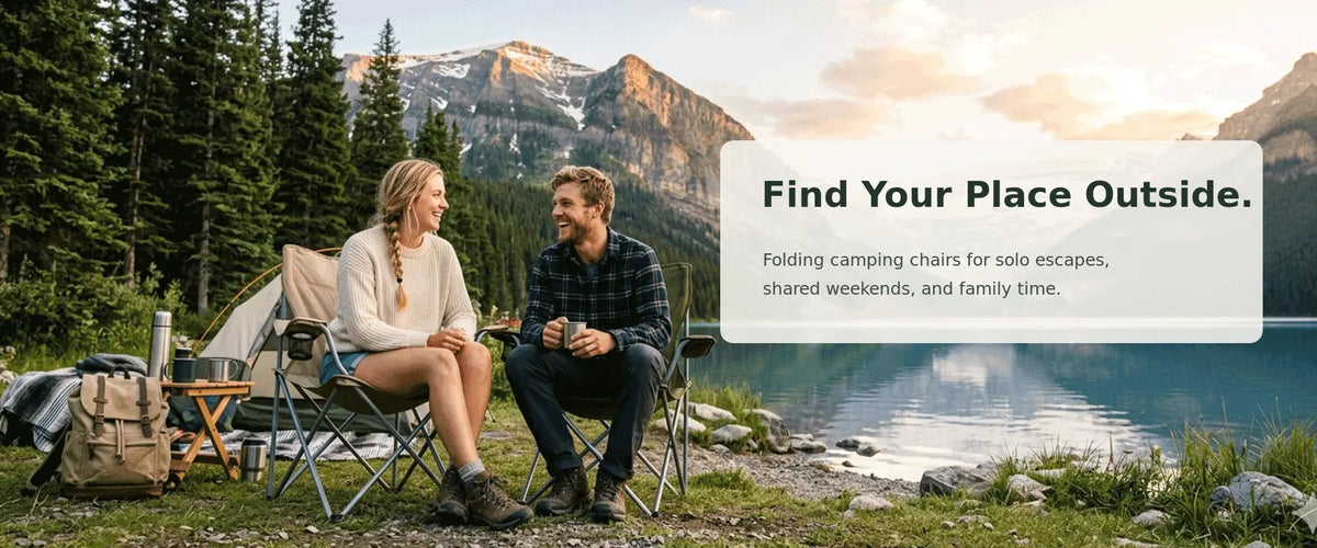 Couple sitting in folding camping chairs by a lake at sunset